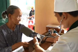 Bác sỹ Bộ đội Biên phòng tỉnh Bình Định khám bệnh miễn phí cho người dân tại xã Hoài Mỹ, huyện Hoài Nhơn. (Ảnh: Nguyên Linh/TTXVN)