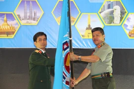 Thiếu tướng Hoàng Kim Phụng nhận cờ đăng cai tổ chức Hội nghị APCN năm 2020 tại Việt Nam. (Ảnh: Hà Ngọc-Hoàng Nhương/Vietnam+)