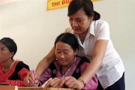 Cô giáo Hà Thị Hằng dạy viết chữ cho học sinh. (Ảnh: Thanh Hải/TTXVN)