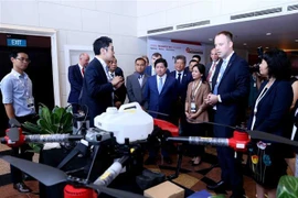Đại biểu dự hội nghị tham quan gian hàng trưng bày sản phẩm. (Ảnh: Vũ Sinh/TTXVN)