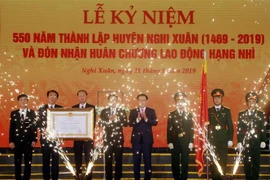 Phó Thủ tướng Vương Đình Huệ trao Huân chương Lao động hạng Nhì cho lãnh đạo huyện Nghi Xuân. (Ảnh: Công Tường/TTXVN)