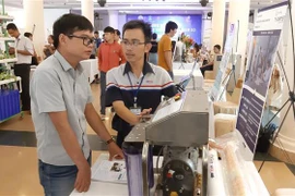 Khách tham quan sản phẩm máy lọc nước biển thành nước ngọt. (Ảnh: Huỳnh Sơn/TTXVN)