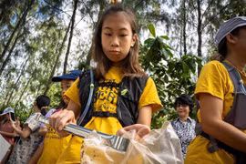 Cô bé Ralyn Satidtanasarn (thứ 2, phải) tham gia dọn rác tại khu vực Khung Bang Kachao, Bangkok, Thái Lan. (Ảnh: AFP/TTXVN)