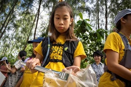 Cô bé Ralyn Satidtanasarn (thứ 2, phải) tham gia dọn rác tại khu vực Khung Bang Kachao, Bangkok, Thái Lan. (Ảnh: AFP/TTXVN)