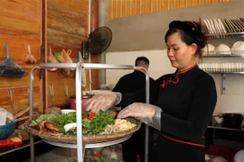 Nhân viên Homestay A Phủ chuẩn bị bữa ăn cho du khách. (Ảnh Quang Đán/TTXVN)