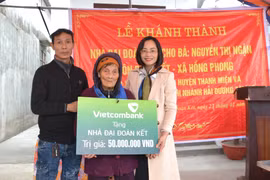 Bà Phạm Minh Đào - Phó Giám đốc Vietcombank Hải Dương (ngoài cùng bên phải) trao biển tặng nhà đại đoàn kết cho gia đình bà Nguyễn Thị Ngận, hộ nghèo thuộc huyện Thanh Miện, tỉnh Hải Dương. (Ảnh: Vietnam+)