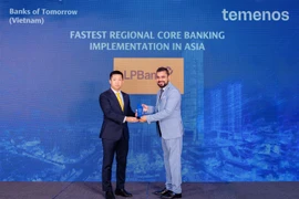 Ông Nikhil Gujral - Phó Tổng Giám đốc khu vực Nam và Đông Nam châu Á Temenos trao cup giải thưởng “Triển khai Core Banking nhanh nhất Châu Á” cho ông Vũ Quốc Khánh - Phó Tổng Giám đốc thường trực LPBank. (Ảnh: Vietnam+)