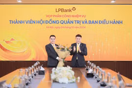 Ông Nguyễn Đức Thụy - Chủ tịch Hội đồng quản trị LPBank (phải) tặng hoa chúc mừng cho ông Hồ Nam Tiến - Phó Chủ tịch thường trực Hội đồng quản trị (trái). (Ảnh: Vietnam+)