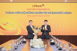 Ông Nguyễn Đức Thụy - Chủ tịch Hội đồng quản trị LPBank (phải) tặng hoa chúc mừng cho ông Hồ Nam Tiến - Phó Chủ tịch thường trực Hội đồng quản trị (trái). (Ảnh: Vietnam+)