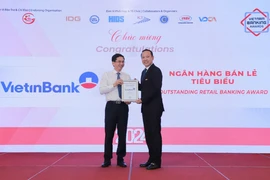 Ông Phạm Quốc Long (bên phải) - Giám đốc Trung tâm khách hàng phía Nam đại diện VietinBank nhận giải thưởng từ ban tổ chức. (Ảnh: Vietnam+)