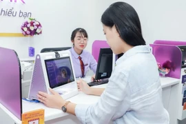 Khách hàng cập nhập khuôn mặt tại phòng giao dịch. (Ảnh: Vietnam+)