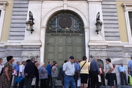 Người được hưởng trợ cấp và lĩnh lương hưu xếp hàng chờ đợi bên ngoài trụ sở Ngân hàng quốc gia Hy Lạp đã đóng cửa ở Athens ngày 29/6. (Nguồn: AFP/TTXVN) 