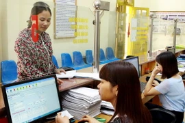 Khách hàng giao dịch tại phòng Một cửa của bảo hiểm xã hội Hưng Yên. (Ảnh: Dương Ngọc/TTXVN) 