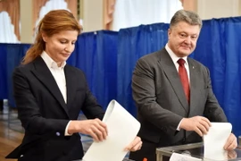 Tổng thống Ukraine Petro Poroshenko (phải) và phu nhân bỏ phiếu tại một địa điểm bầu cử ở Kiev. (Nguồn: AFP/TTXVN)