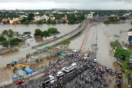 Mọi người chứng kiến cảnh nước lũ tràn qua đường cao tốc ở Chennai. (Nguồn: ibtimes)