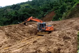 Máy múc được huy động tới giải tỏa điểm sạt lở nặng tại bản Pù Toong xã Pù Nhi, huyện Mường Lát. (Ảnh: Trịnh Duy Hưng/TTXVN)