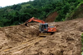 Máy múc được huy động tới giải tỏa điểm sạt lở nặng tại bản Pù Toong xã Pù Nhi, huyện Mường Lát. (Ảnh: Trịnh Duy Hưng/TTXVN)