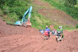 Đơn vị quản lý tuyến Quốc lộ 4H đang dọn sạch bùn nhão trên nền đường, đảm bảo cho các phương tiện giao thông qua lại. (Ảnh: Văn Dũng/TTXVN)
