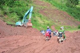 Đơn vị quản lý tuyến Quốc lộ 4H đang dọn sạch bùn nhão trên nền đường, đảm bảo cho các phương tiện giao thông qua lại. (Ảnh: Văn Dũng/TTXVN)