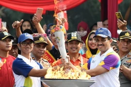 Thị trưởng thành phố Đông Jakarta, ông M. Anwar (phải) tham gia lễ tiếp đuốc. (Nguồn: THX/TTXVN)