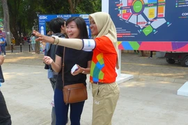 Một tình nguyện viên đang hướng dẫn khách. (Ảnh: Đỗ Quyên/Vietnam+)