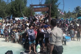 Hàng trăm khách du lịch chờ sơ tán khỏi Gili Trawangan, khu vực lân cận đảo Lombok, Indonesia. (Nguồn: AFP/TTXVN)