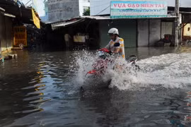 Nước ngập sâu trên đường phường Thạnh Lộc. (Ảnh: Mạnh Linh/TTXVN)