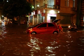 Rất nhiều ôtô và xe máy bị chết máy do đi qua đoạn đường ngập sâu. (Ảnh: Phạm Kiên/TTXVN)