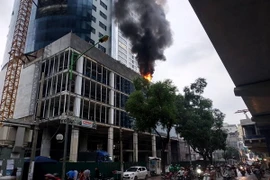 Khói bốc cao hàng mét khiến người đi đường hoảng sợ. (Ảnh: Lê Minh Sơn/Vietnam+)