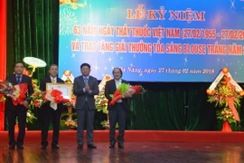 Phó Bí thư Thường trực Thành ủy Đà Nẵng Võ Công Trí trao Huân chương Lao động hạng Nhì cho Trung tâm Y tế quận Hải Châu. (Ảnh: Đinh Văn Nhiều/TTXVN)