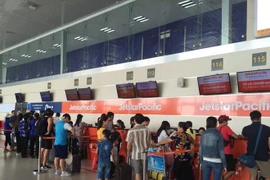Hành khách đang làm thủ tục tại quầy của Jetstar. (Ảnh: Việt Hùng/Vietnam+)