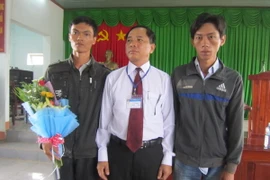 Đại diện Tòa án Nhân dân tỉnh Bình Phước cùng hai thanh niên bị oan sai. (Ảnh: Đậu Tất Thành/TTXVN.)