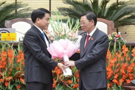 Ông Nguyễn Thế Thảo, Nguyên Chủ tịch Ủy ban Nhân dân thành phố Hà Nội, chúc mừng ông Nguyễn Đức Chung. (Ảnh: Nguyễn Văn Cảnh/Vietnam+)