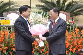 Ông Nguyễn Thế Thảo, Nguyên Chủ tịch Ủy ban Nhân dân thành phố Hà Nội, chúc mừng ông Nguyễn Đức Chung. (Ảnh: Nguyễn Văn Cảnh/Vietnam+)