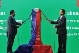 Thủ tướng Nguyễn Tấn Dũng (bên phải) và Thủ tướng Hun Sen thực hiện nghi thức mở tấm vải phủ Cột mốc 275 tại buổi lễ khánh thành. (Ảnh: Trọng Đức/TTXVN)