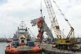 Lực lượng cứu hộ Indonesia chuyển mảnh vỡ lớn cuối cùng của máy bay QZ8501 lên cảng Tanjung Priok ở Jakarta ngày 2/3. (Nguồn: AFP/TTXVN)