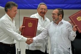 Tổng thống Colombia Juan Manuel Santos (trái) và thủ lĩnh FARC Timoleon Jimenez (phải) trong lễ ký thỏa thuận ngừng bắn vĩnh viễn dưới sự chứng kiến của Chủ tịch Cuba Raul Castro. (Nguồn: AFP/TTXVN)