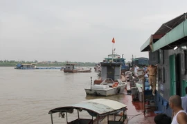 Lực lượng chức năng tỉnh Thái Bình đang khẩn trương điều tra làm rõ nguyên nhân vụ chìm tàu trên sông Hồng. (Ảnh: Xuân Tiến/TTXVN)