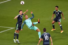 Cristiano Ronaldo (giữa) tranh bóng bổng với các cầu thủ Xứ Wales. (Nguồn: EPA/TTXVN)