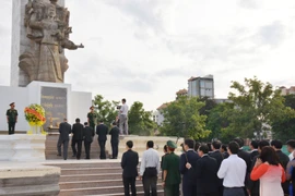 Đoàn Đại sứ quán, các cơ quan xung quanh Sứ quán, đại diện doanh nghiệp Việt Nam đang đầu tư kinh doanh tại Campuchia và cộng đồng người Việt Nam định cư tại Campuchia đặt vòng hoa viếng Đài tưởng niệm quân tình nguyện Việt Nam ở thủ đô Phnom Penh. (Ảnh: 