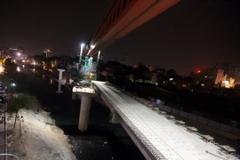 Đơn vị thi công tiến hành việc lắp đặt phiến dầm vượt qua sông Tô Lịch tại trụ DR14 sang DR13. (Ảnh: Huy Hùng/TTXVN)