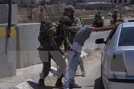 Binh sỹ Israel khám xét người dân Palestine tại một điểm kiểm soát ở trại tị nạn Fawwar ngày 16/8. (Nguồn: THX/TTXVN)
