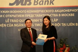 Thiếu tướng Lê Công trao quyết định thành lập Văn phòng đại diện cho bà Trần Minh Phượng, Trưởng Văn phòng đại diện của MB tại Liên bang Nga. (Ảnh: Dương Trí/Vietnam+)