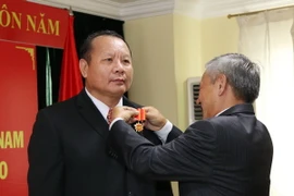 Đại sứ Nguyễn Mạnh Hùng gắn Huân chương Hữu nghị cho ông Kiengkham Inphengthavong, Đại tá, Phó Chánh Văn phòng Bộ An ninh Lào, nguyên Trưởng Cơ quan đại diện Bộ An ninh Lào tại Việt Nam. (Ảnh: Phạm Kiên/TTXVN)