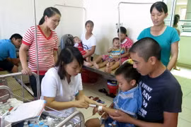 Bác sỹ thăm khám và điều trị cho trẻ bị ngộ độc thực phẩm tại Bệnh viện Nhi Nam Định. (Ảnh: Văn Đạt/TTXVN)