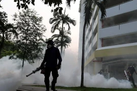 Nhân viên y tế phun thuốc diệt muỗi truyền virus Zika tại khu vực Aljunied, Singapore ngày 28/8. (Nguồn: AFP/TTXVN)