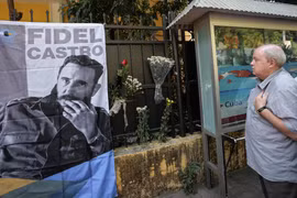 Một người đàn ông nghiêm trang đặt hoa cạnh bức ảnh nhà lãnh tụ vĩ đại Fidel Castro. (Ảnh: Minh Sơn/Vietnam+)