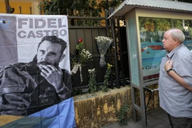 Một người đàn ông nghiêm trang đặt hoa cạnh bức ảnh nhà lãnh tụ vĩ đại Fidel Castro. (Ảnh: Minh Sơn/Vietnam+)