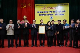 Bí thư Tỉnh ủy Bắc Ninh Nguyễn Nhân Chiến chúc mừng nhân dân huyện Thuận Thành nhận nhãn hiệu tập thể gà Hồ. (Ảnh: Thanh Thương/TTXVN)