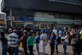 Người dân Venezuela xếp hàng chờ giao dịch bên ngoài Ngân hàng Trung ương ở Caracas. (Nguồn: EPA/TTXVN)